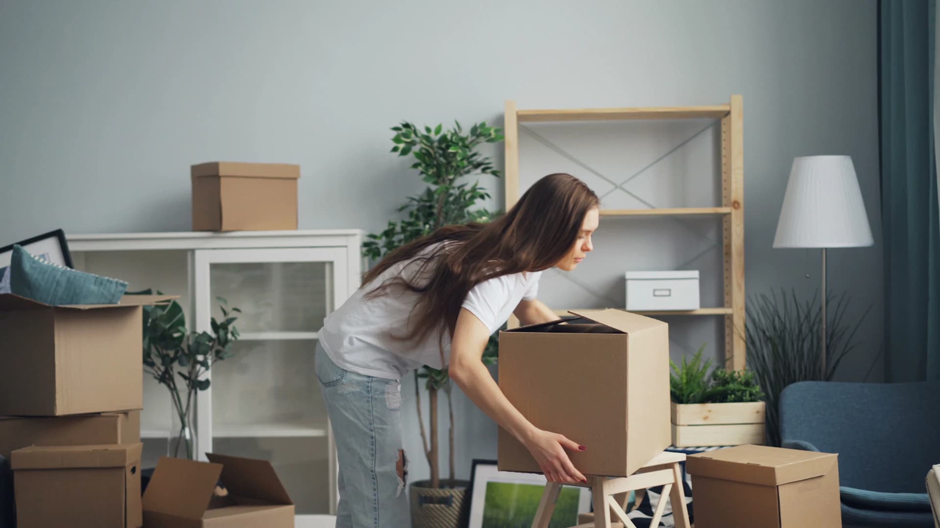 Person packing moving boxes in a living room